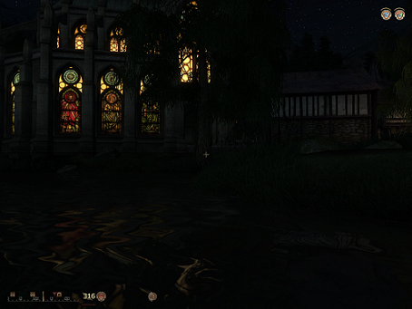 Small screenshot of the PC game, Oblivion, depicting a church with lit stained glass windows reflecting in the water at night.